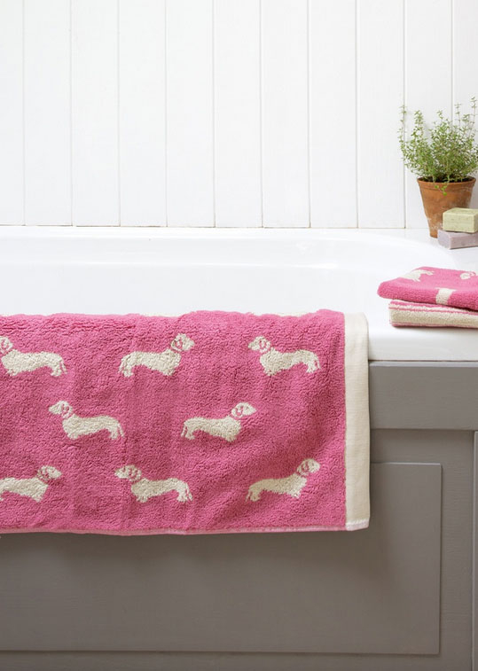 Dackel auf Badematte im Himbeerton