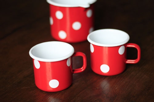 roter Becher mit weißen Punkten aus Emaille